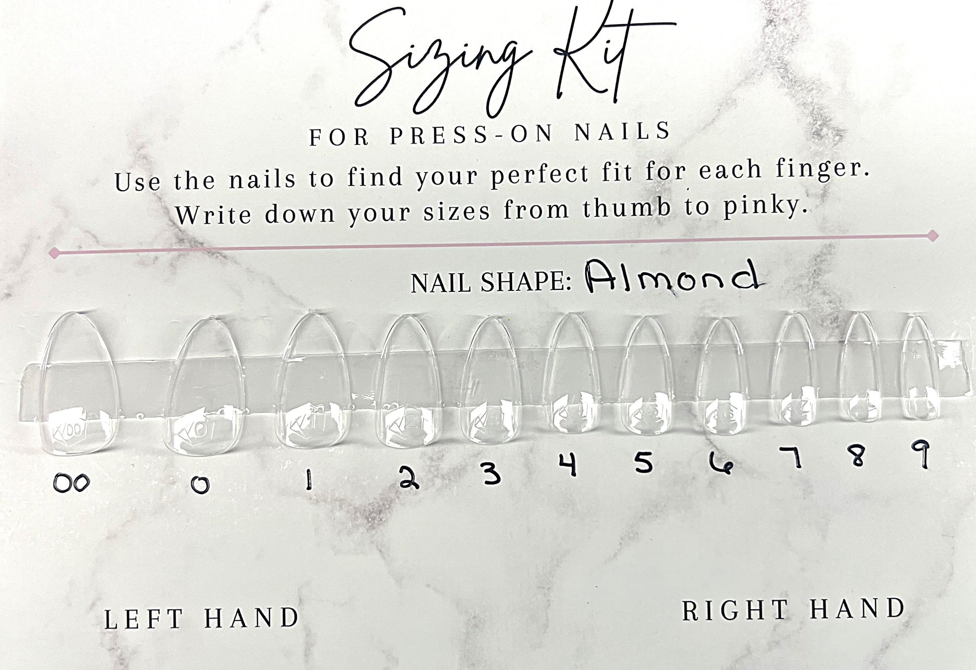 Astral Hue Sizing Kit for press-on nails. A white marble-patterned card featuring 11 clear Après Gel-X almond-shaped nail tips labeled 00 through 9. Includes instructions to find the perfect fit and spaces to write down sizes for the left and right hands.
