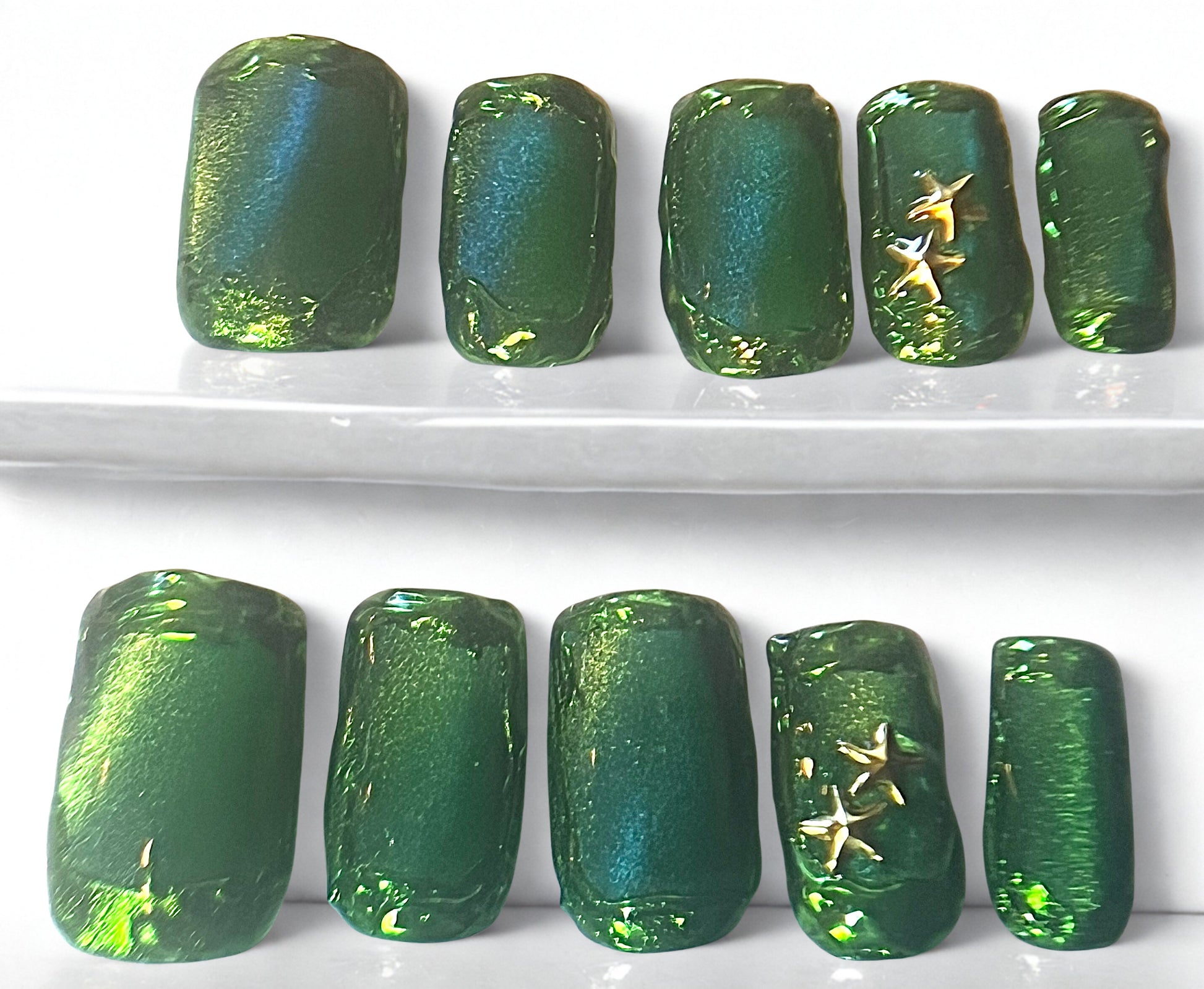 Emerald Abyss press-on nails featuring a deep green jelly base with a magnetic cat-eye shimmer. The design includes reflective mirror gold chrome accents and a high-gloss finish on a square shape.