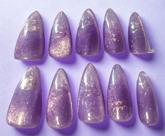 Shimmering Aquarius press-on nails featuring a lavender base with a gold magnetic velvet cat-eye shimmer. Decorated with holographic Aquarius zodiac water-bearer symbols. Medium stiletto-almond shape with a high-gloss finish.