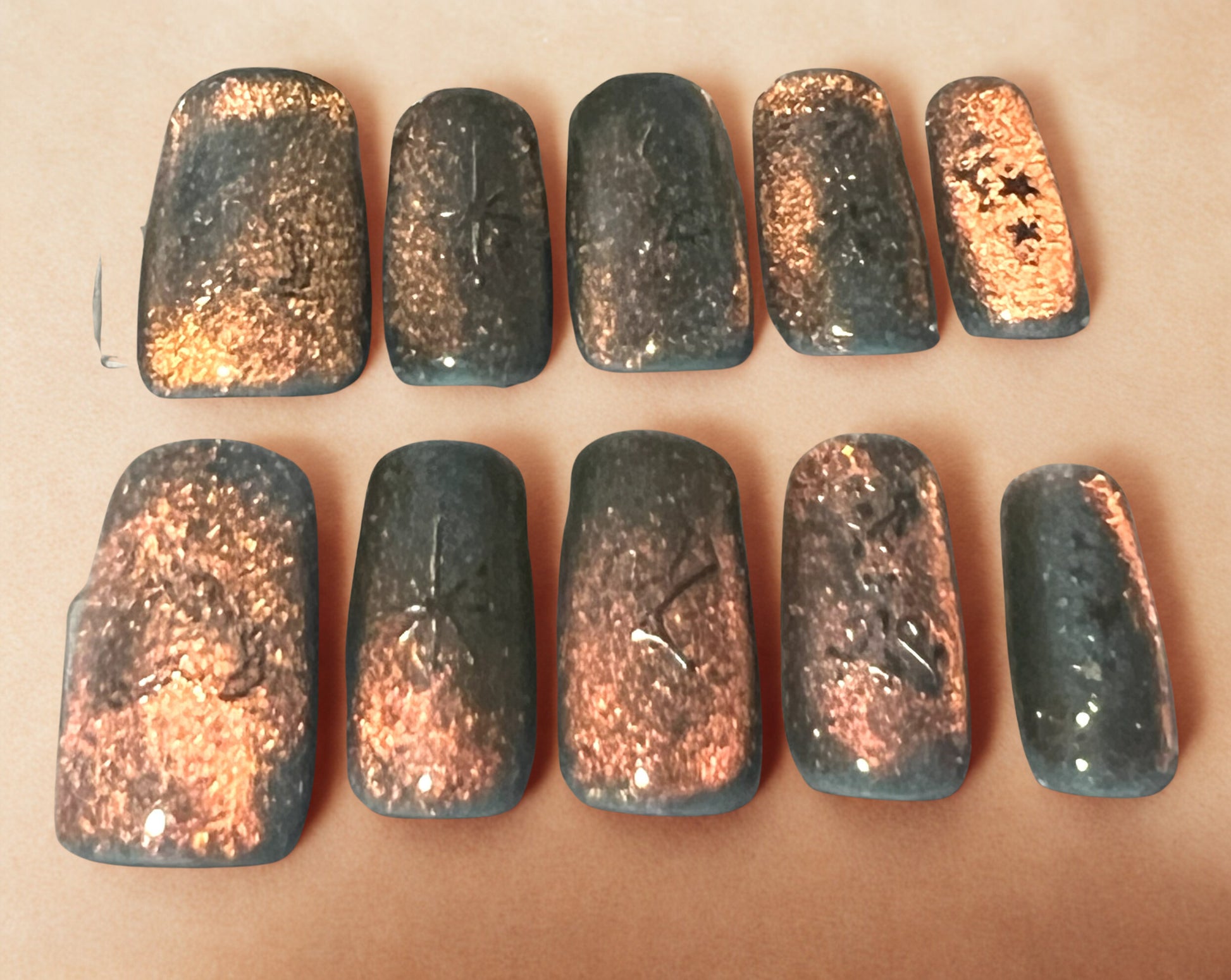 Love on the Horizon press-on nails featuring a light blue base with a 9D velvet cat-eye shifting through orange, pink, and green. Each nail is decorated with holographic celestial stickers like stars and moons. Medium square shape with a high-gloss, glowing sunset finish.